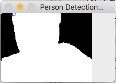 Thresholded thermal silhouette showing person detection - warm body isolated as white region against dark background